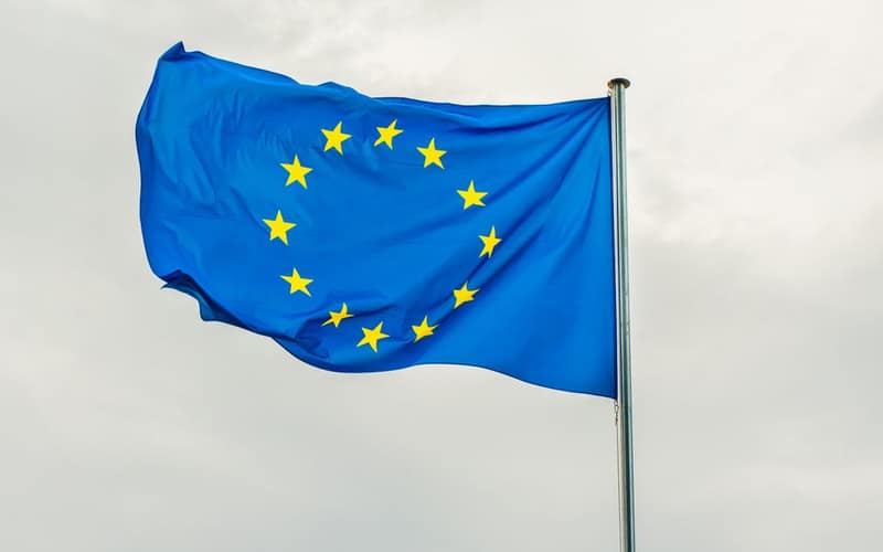 The European Union flag gracefully waving on a flagpole against a cloudy sky in Strasbourg, France.