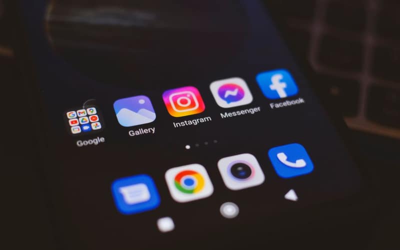 Uno smartphone che mostra app di social media popolari in un ambiente scarsamente illuminato, ideale per temi tech e di comunicazione.