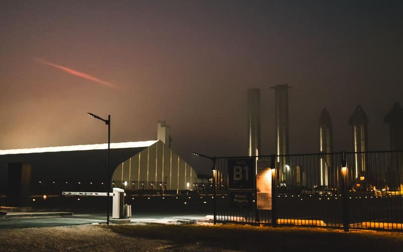 Dramatic night view of SpaceX facility with fog and lights in Brownsville, Texas.