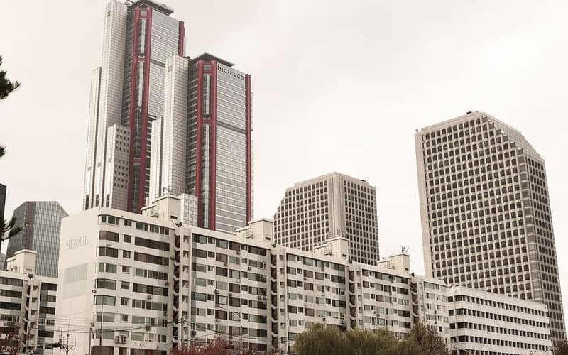 View of modern skyscrapers against a cloudy sky in downtown Seoul during fall.