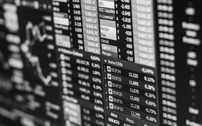 Monochrome image of stock market data on a screen, depicting financial information and trends.