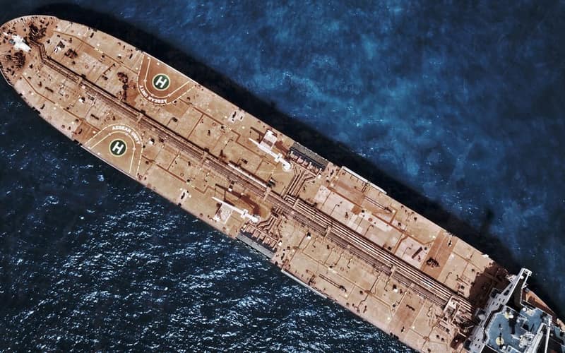 Drone shot of large tanker ship with helipads in ocean waters.