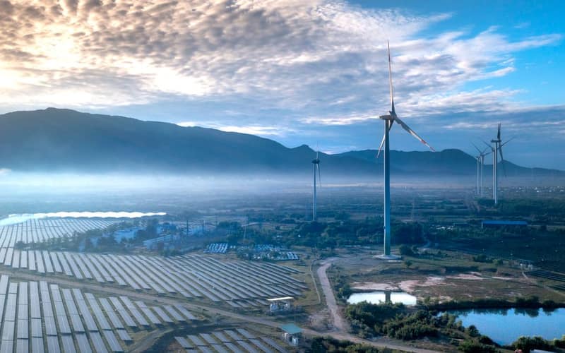 Stunning aerial view of wind turbines and solar panels in a landscape, showcasing renewable energy technologies.