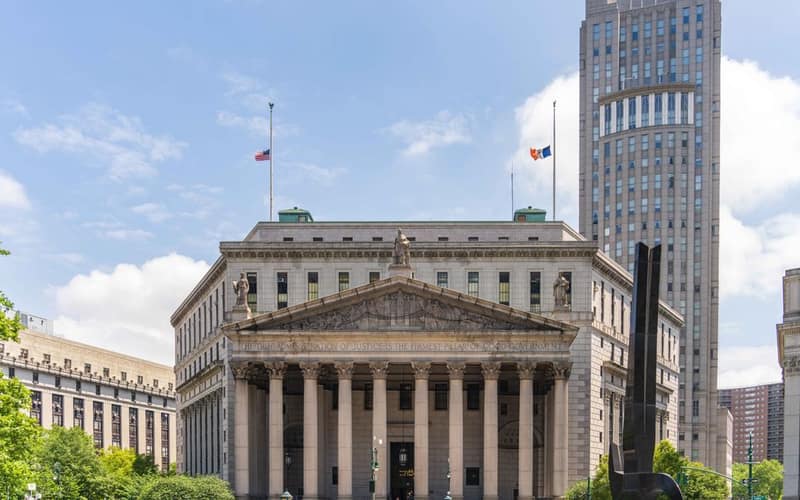 View of the historic New York County Courthouse with clear skies and cityscape.