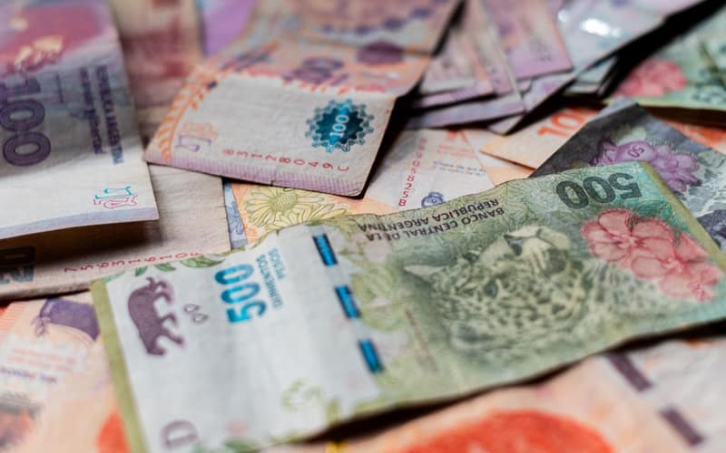 A detailed image showcasing various Argentine peso banknotes in vivid colors.