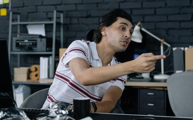 Young professional gesturing while discussing ideas in a modern office setting.