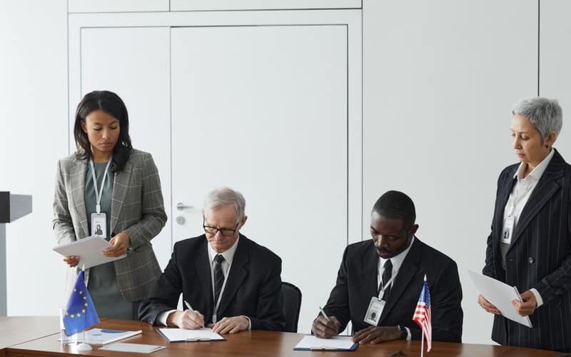 Business leaders signing a significant agreement in a conference room setting.