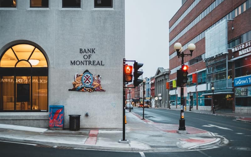 Empty asphalt road and pavement with modern bank with symbol sign under gloomy sky