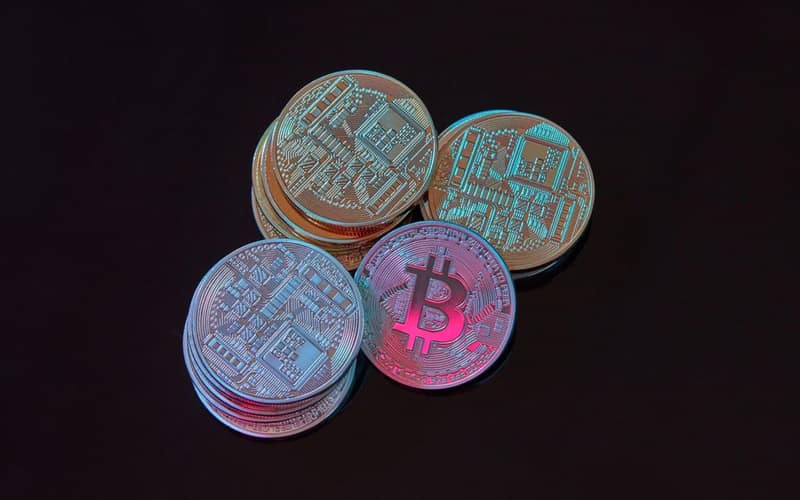 A detailed image showcasing a stack of Bitcoin cryptocurrency coins on a black background.