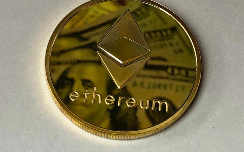 Close-up of a shining Ethereum coin reflecting a dollar bill, symbolizing digital currency and wealth.