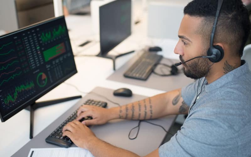 A trader studying multiple screens of stock charts, representing a hedge fund positioning against chip stocks.