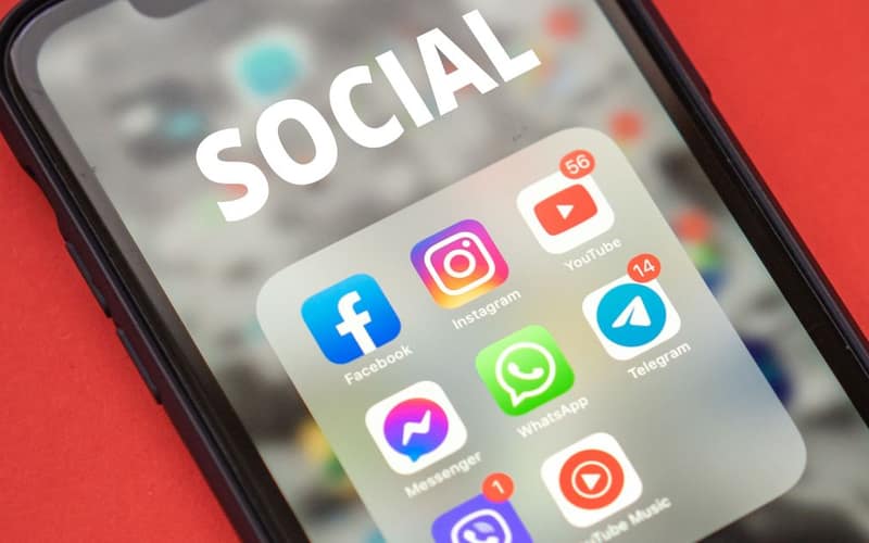 Close-up of a smartphone showing popular social media apps on screen.